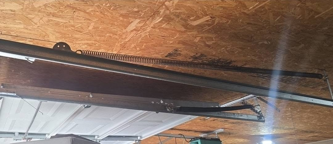 Garage door opener rail and extension spring mounted along the ceiling